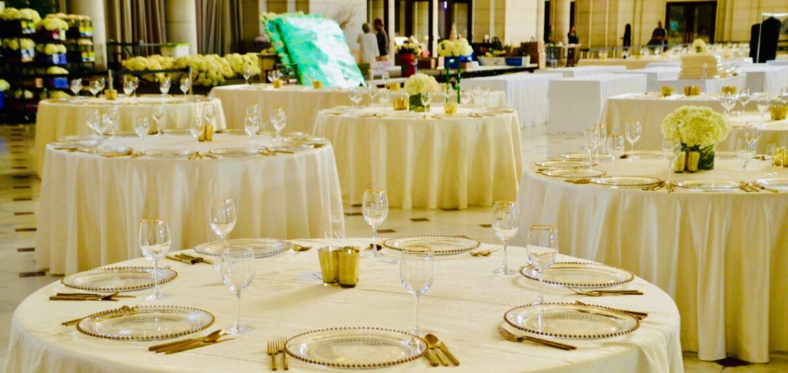 Mesas de catering dispuestas en buffet con mantelería blanca en un evento corporativo